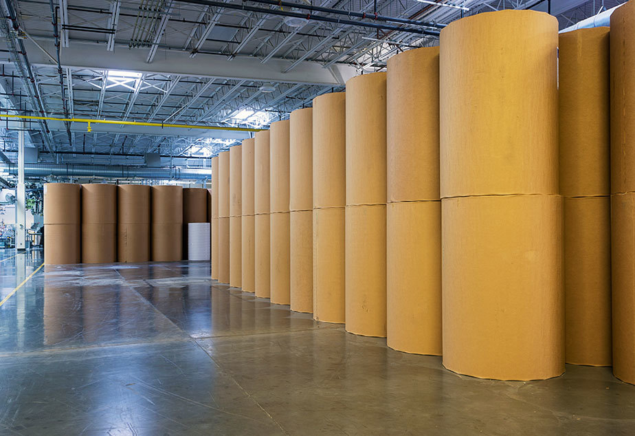 yellow rolls of cardboard paper corrugated packaging industry warehouse